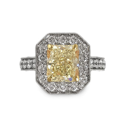 2.04 carat radiant cut Fancy Yellow diamond ring with 0.78 CTW diamond halo in 18K two-tone gold.