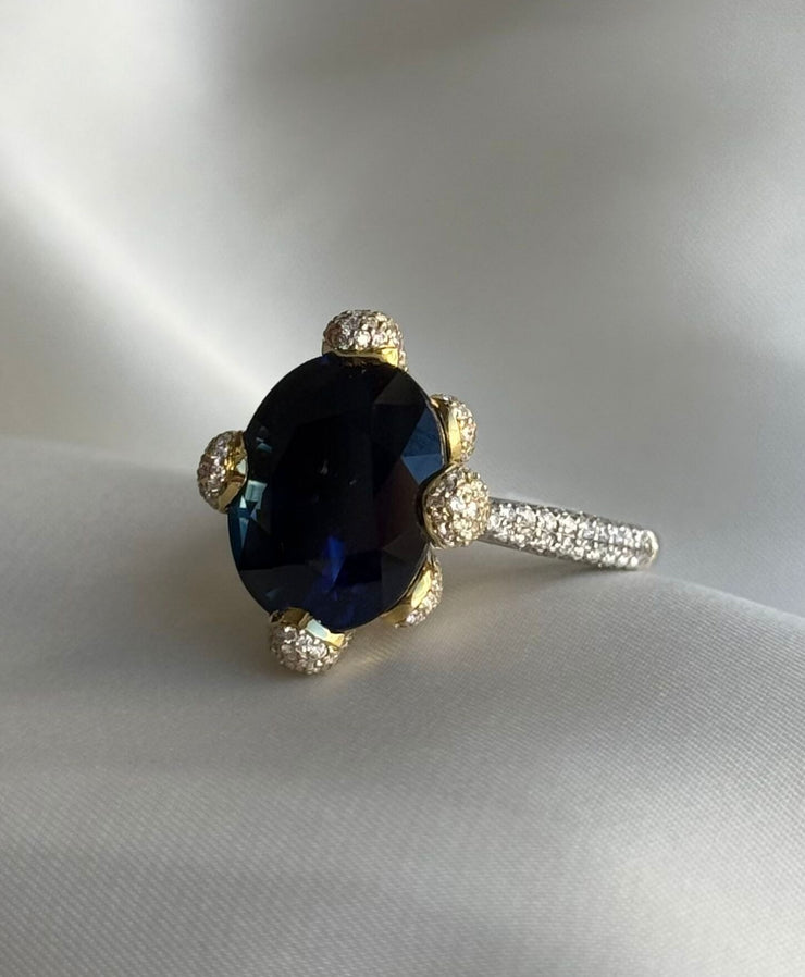 Rich deep blue hue sapphire sits center stage in this two tone ring. 