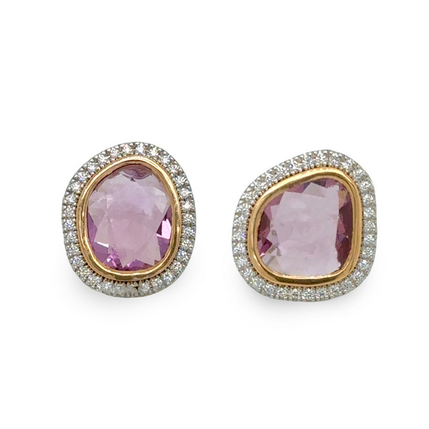 Pair of stud earrings with pink sapphire gemstones bezel set with a diamond halo on a white background