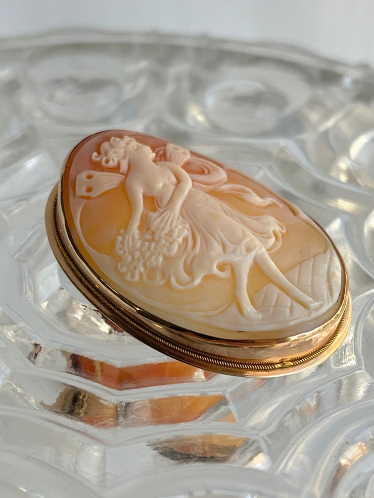 This close-up image reveals the intricate hand-carved details of the cameo—graceful curls, lifelike facial features, and subtle depth. The 14K yellow gold bezel is finely finished with ornate edges that reflect the craftsmanship and artistry of a bygone era.