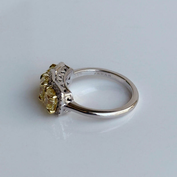 Side view of three-stone diamond ring with 2.22ct Fancy Yellow diamonds and round diamonds in two tone 18K gold.