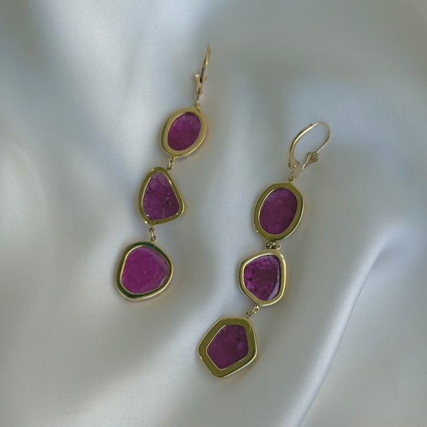 Back view of pair of no-heat ruby slice earrings with yellow gold bezel setting against white background
