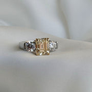 Two-tone platinum and yellow gold ring with emerald-cut Fancy Yellow diamond and round side stones