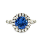 Blue sapphire engagement ring with round diamond halo and white gold band