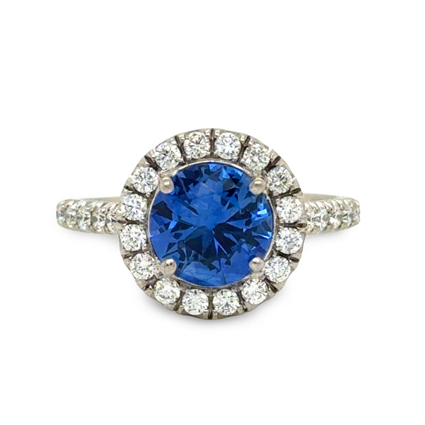 Blue sapphire engagement ring with round diamond halo and white gold band