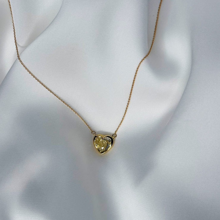 Heart-shaped yellow diamond necklace on silk