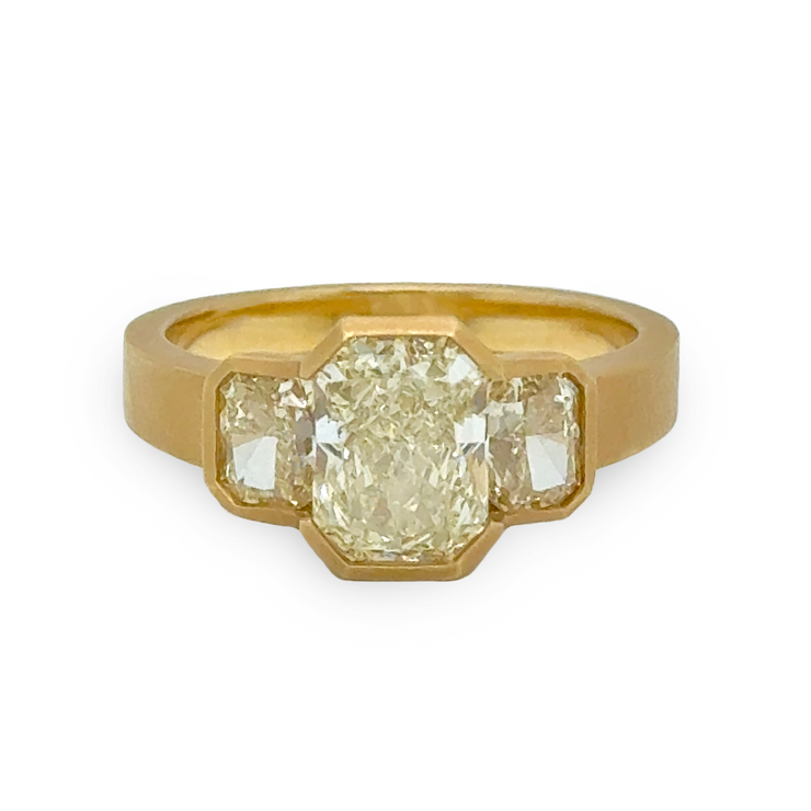 Matte gold ring with a large yellow diamond and two smaller yellow diamonds on a white background
