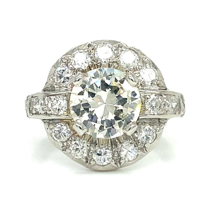 The 1.20 ct center diamond is wrapped in a soft halo and shimmering band, with approx. 0.60 ctw of accents that add sparkle from every angle.