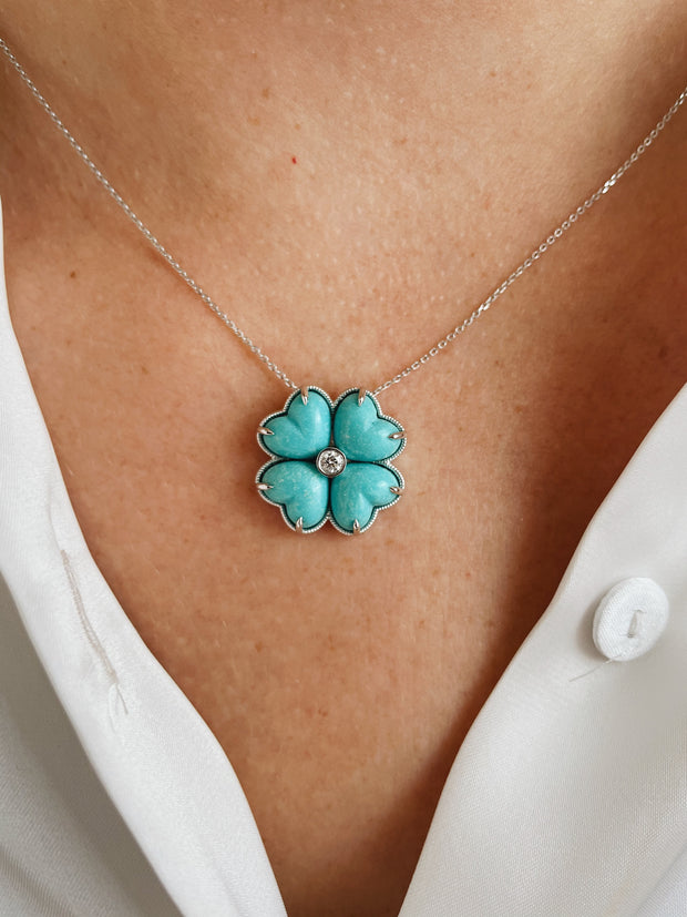 Turquoise cabochon clover pendant with diamond accent shown on a model