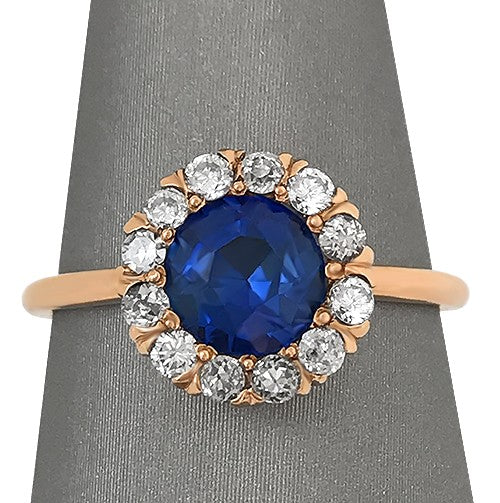 Close up view showingcasing the depth of blue sapphire encircled by a halo of 12 sparkling diamonds.