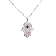 18K white gold Hamsa pendant featuring round brilliant cut diamonds and a central sapphire.