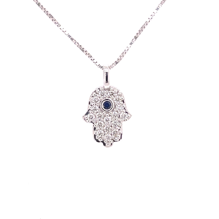 18K white gold Hamsa pendant featuring round brilliant cut diamonds and a central sapphire.