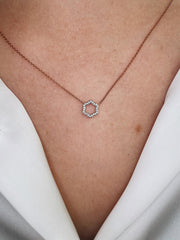 Two-tone 18k gold and diamond hexagonal necklace shown on model.