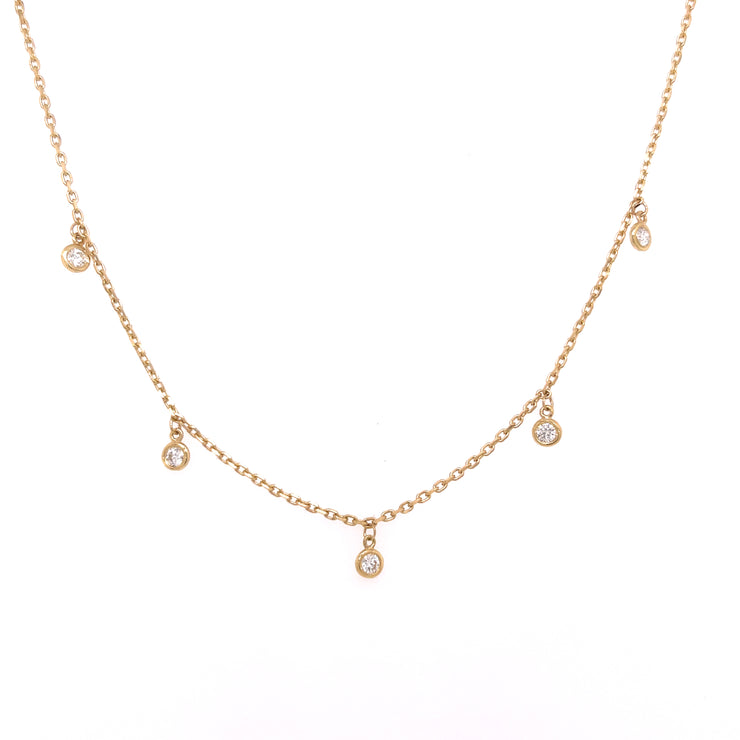 A 14K yellow gold necklace featuring a series of round brilliant cut bezel-set diamonds.