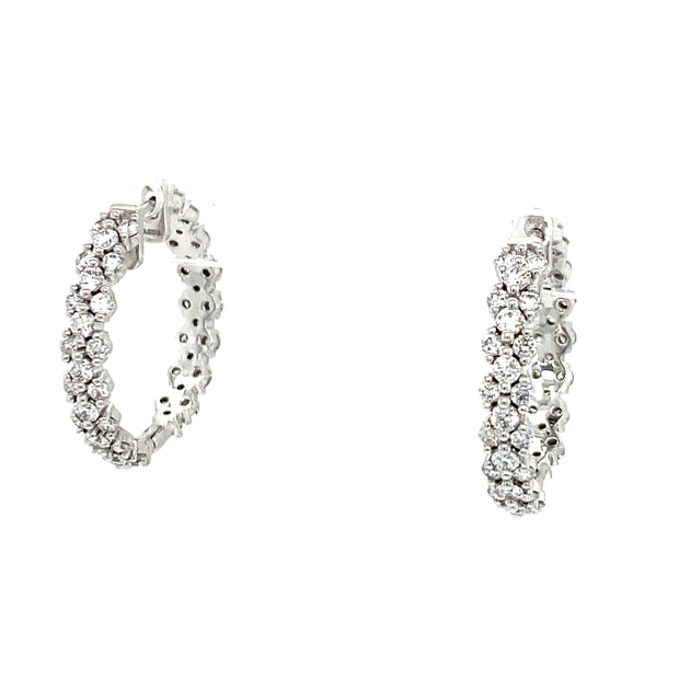 A pair of 18K white gold hoop earrings with round brilliant cut diamonds.