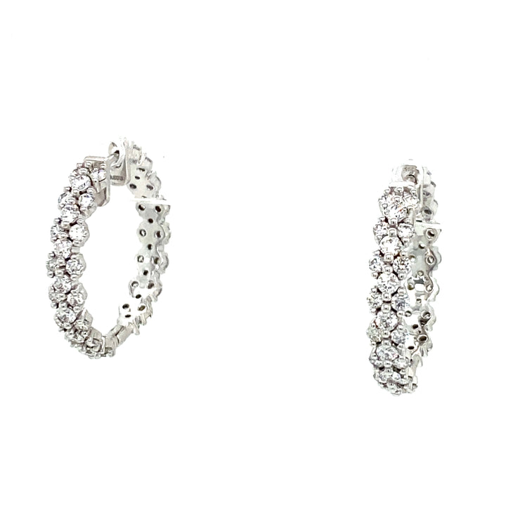 A pair of 18K white gold hoop earrings with round brilliant cut diamonds.