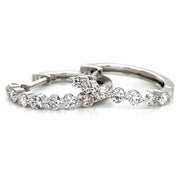 A pair of 18k white gold mini hoop earrings set with round brilliant diamonds.