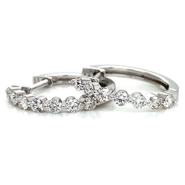 A pair of 18k white gold mini hoop earrings set with round brilliant diamonds.