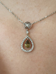 A stunning close look at the green diamond pendant on model.