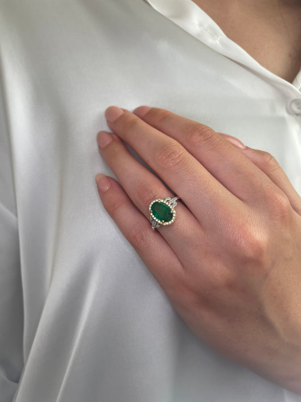 Another look at the emerald and diamond halo ring on hand.