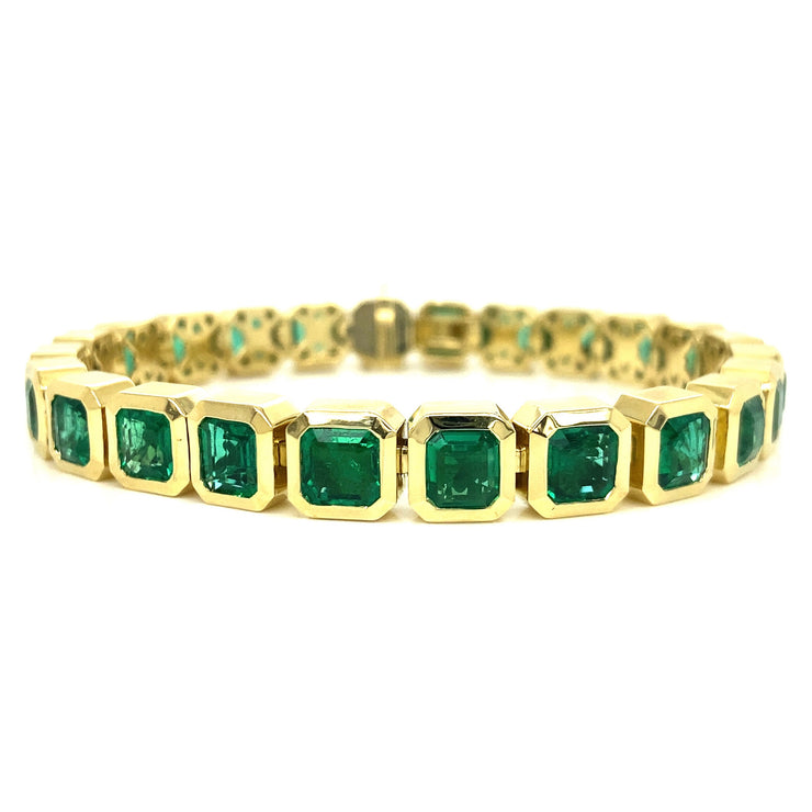 Emerald tennis bracelet with natural green stones bezel-set in 18K yellow gold, showcasing elegant craftsmanship and vibrant color