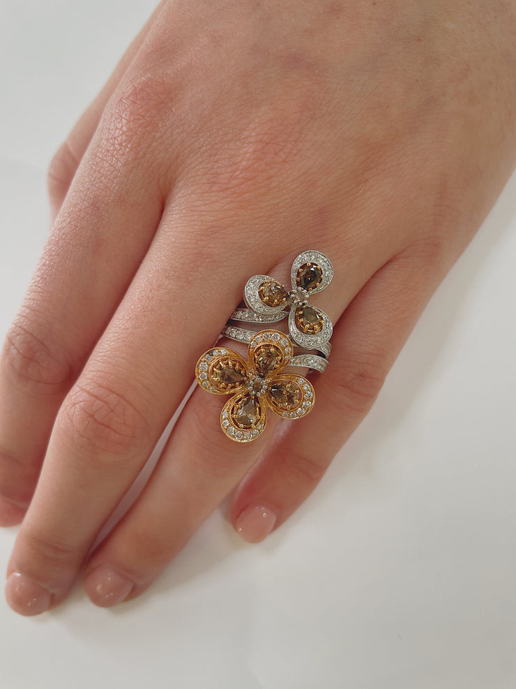 Luxury floral diamond ring worn on hand, showcasing chocolate and white diamonds in rose and white gold.