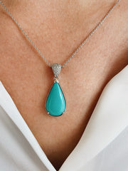 Turquoise and diamond pendant shown on model.