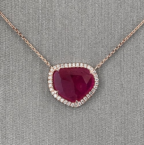Close up of the ruby slice with diamond halo set in 18K rose gold.