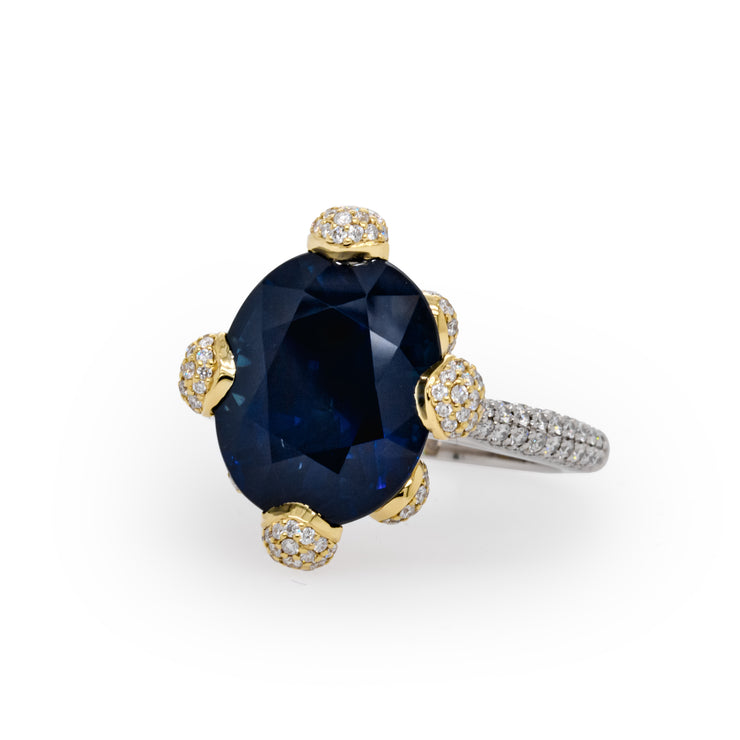An oval cut sapphire ring with round brilliant cut diamonds pave and micropave set in 18 karat yellow gold and platinum.