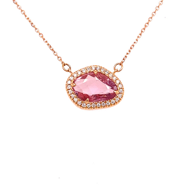 Surrounding the center stone, a delicate halo of 0.08 carats of round brilliant cut diamonds.