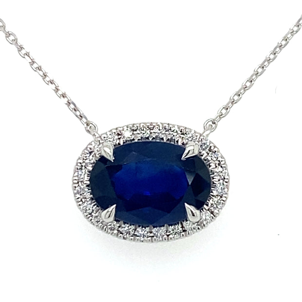 Deep blue Sapphire sits at the center of natural diamond halo on an 18inch white gold chain
