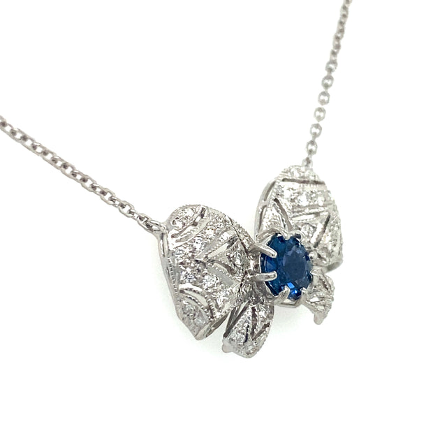 Natural diamond and sapphire bow pendant necklace show from the side.