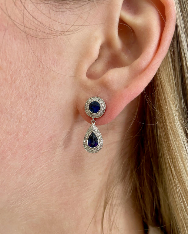 Double sapphire dangle drop earrings on model.