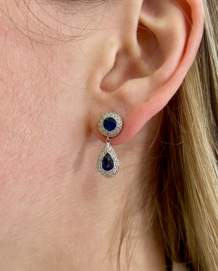 Double sapphire dangle drop earrings on model.