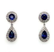 A pair of dangle earrings featuring sapphire gemstones with diamond halos, set in a platinum band.