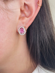 Pair of pink sapphire slice and diamond halo earrings shown on model.