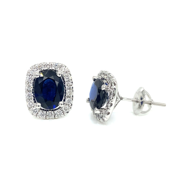Pair of sapphire earrings featuring round brilliant diamond halos.