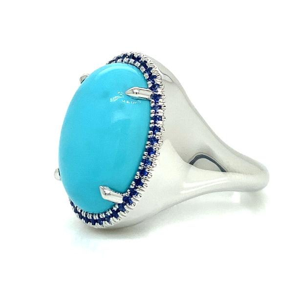 Side view of Turquoise cabochon center stone surrounded by blue sapphire halo