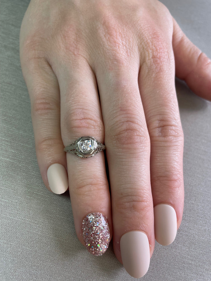 0.20ct round brilliant cut diamond with vintage sparkle shown on hand.