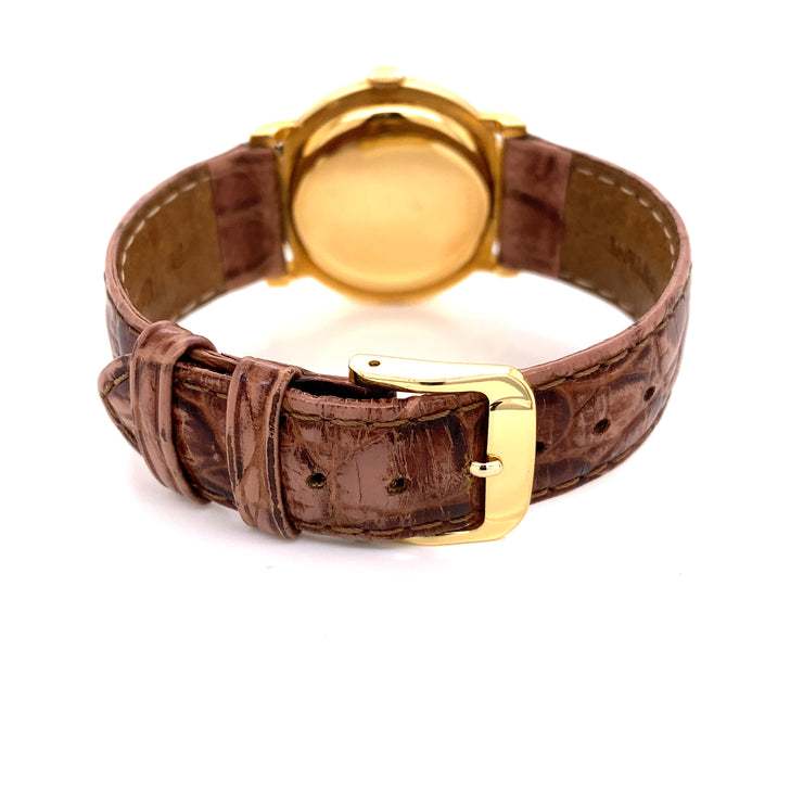 Closer detailing of the 18K yellow gold tang buckle on brown leather croc strap.