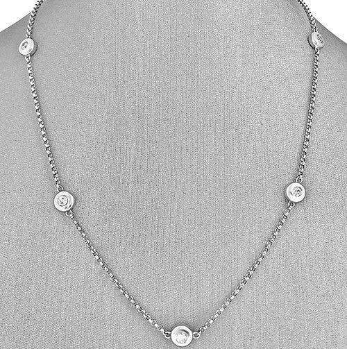 A 14 karat white gold diamond necklace with bezel set round brilliant cut diamonds.
