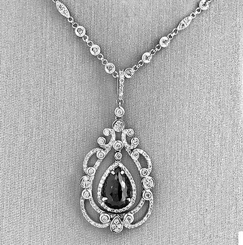 Diamond drop pendant on diamond bezel chain.