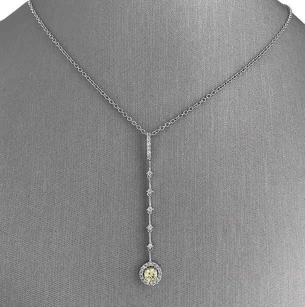 An 18 karat white gold diamond dangle pendant set with round brilliant cut fancy yellow and white diamonds.