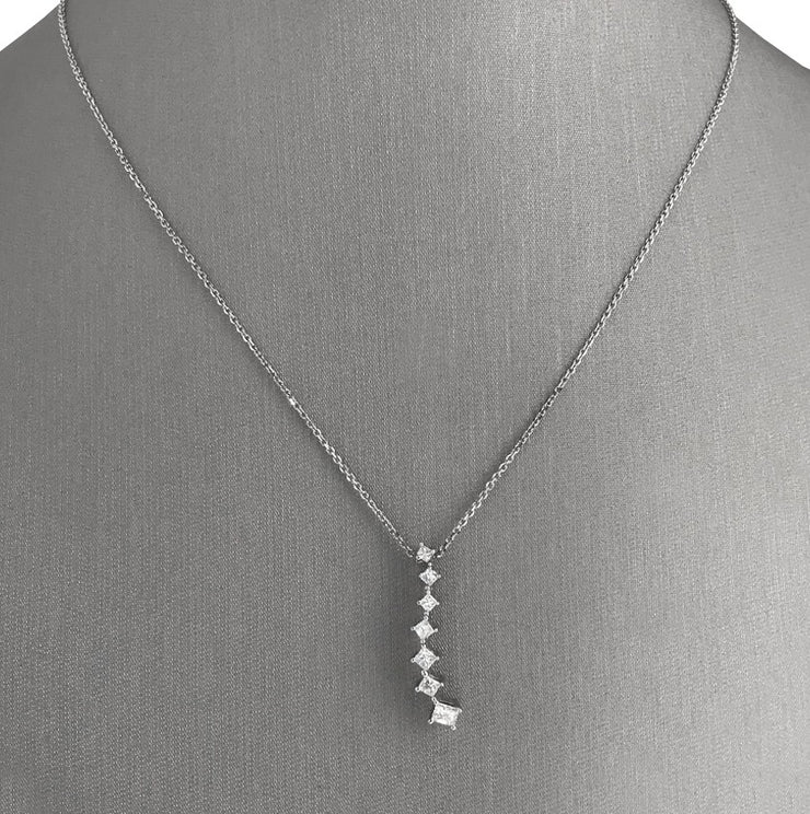 A 14 karat white gold cascading diamond pendant set with 7 princess cut diamonds.