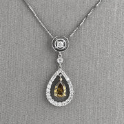 Green pear-shaped diamond with diamond halo drop pendant necklace.