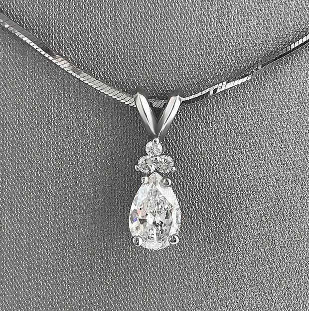 Beautiful pear-shaped diamond with atrio of round diamond accents.