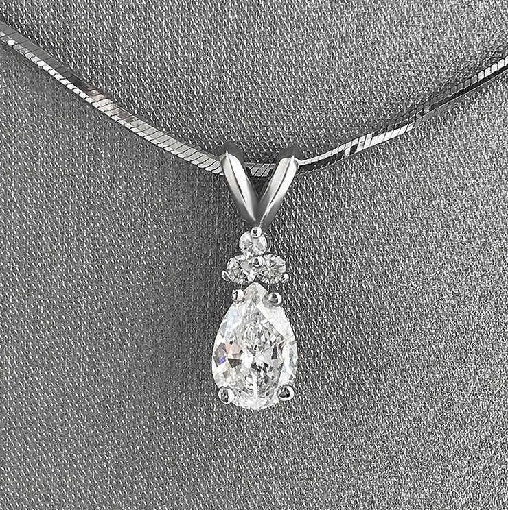 Beautiful pear-shaped diamond with atrio of round diamond accents.