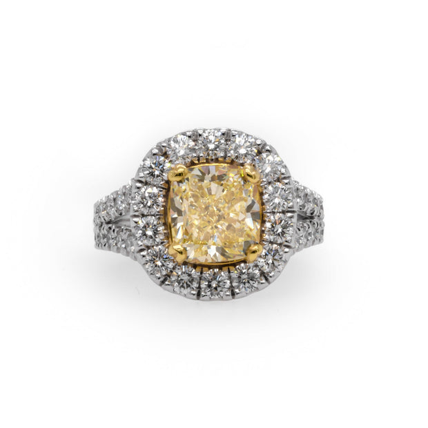Fancy yellow 3.01 CT diamond with round brilliant halo in 18K two-tone gold.
