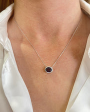 Model wearing 1.86 carat sapphire pendant with 0.09 carat diamond halo set in 18K white gold, showcasing elegant and timeless fine jewelry