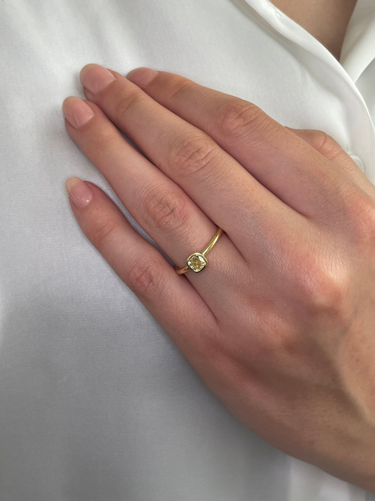 18k yellow gold ring with bezel-set 0.53 carat fancy yellow diamond worn by a model.